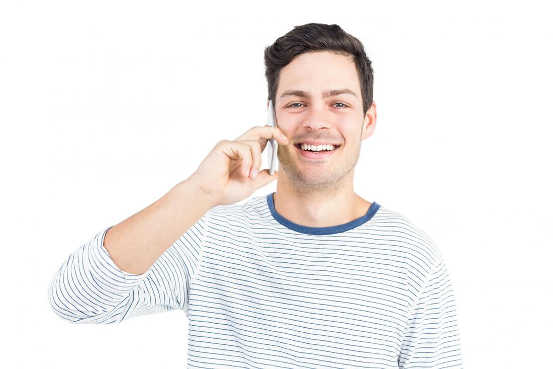 man smiling while talking to his phone 