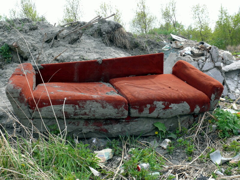 dirty red sofa in the middle of somewhere 