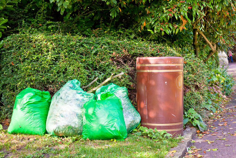green garbage bags and trash can
